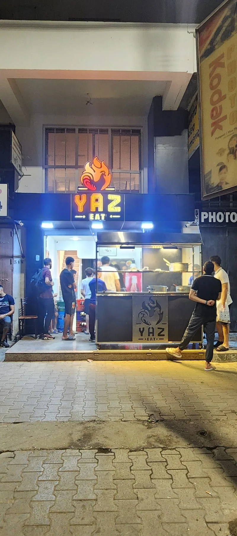Façade publique de Yaz Eat à Les Bananiers, avec enseigne lumineuse YAZ EAT et flamme